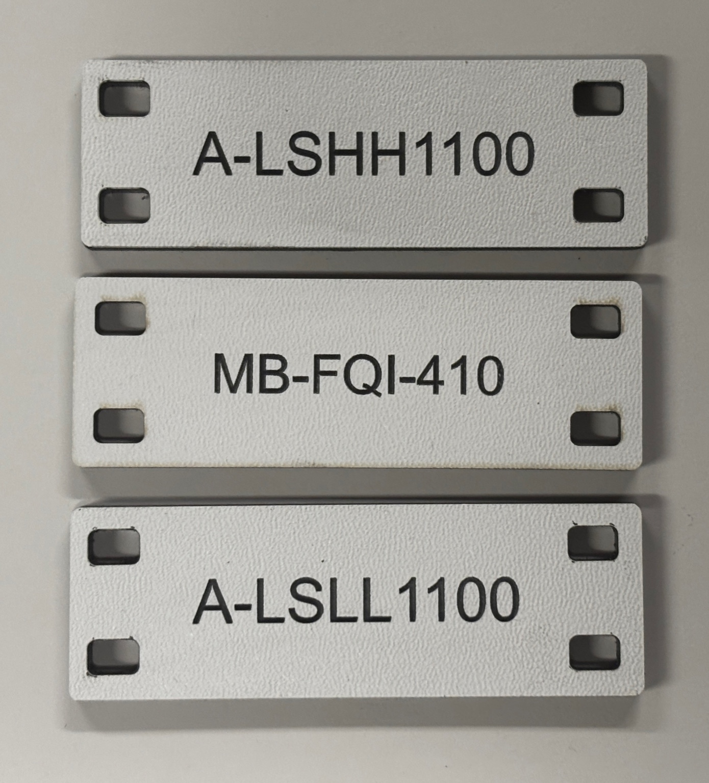 White engraved industrial equipment tags with mounting slots